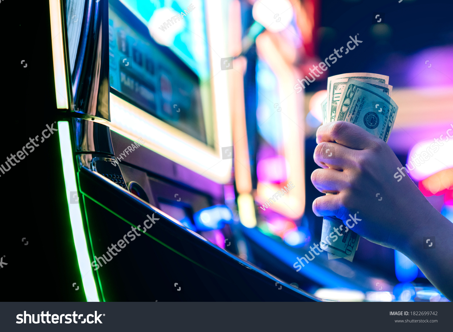 Slot Machine Play Time. Female Gambler Hand hold money bill ready to win the game with one best shot casino close up #1822699742