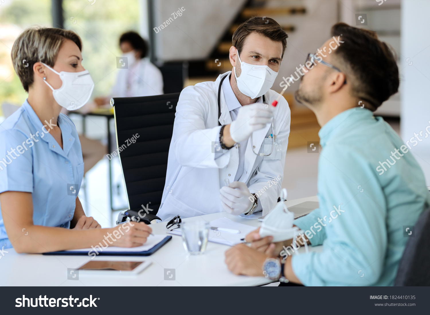 Doctor wearing protective face mask and using cotton swab while doing PCR test of a patient during coronavirus pandemic.  #1824410135