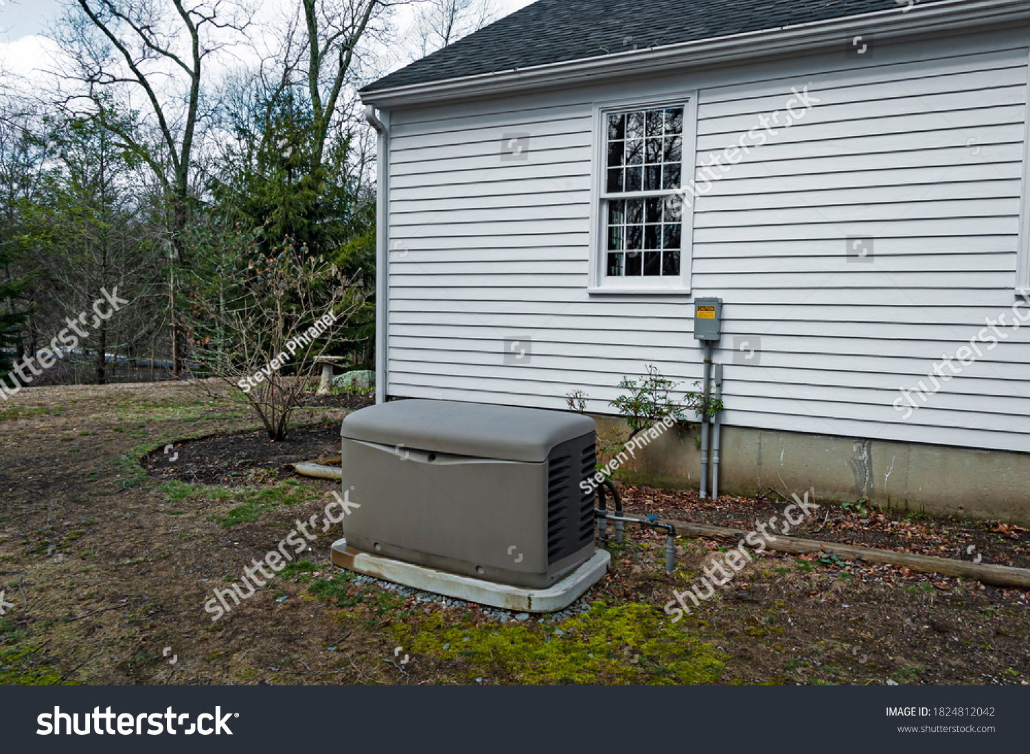 Residential standby generator installed on a concrete pad #1824812042