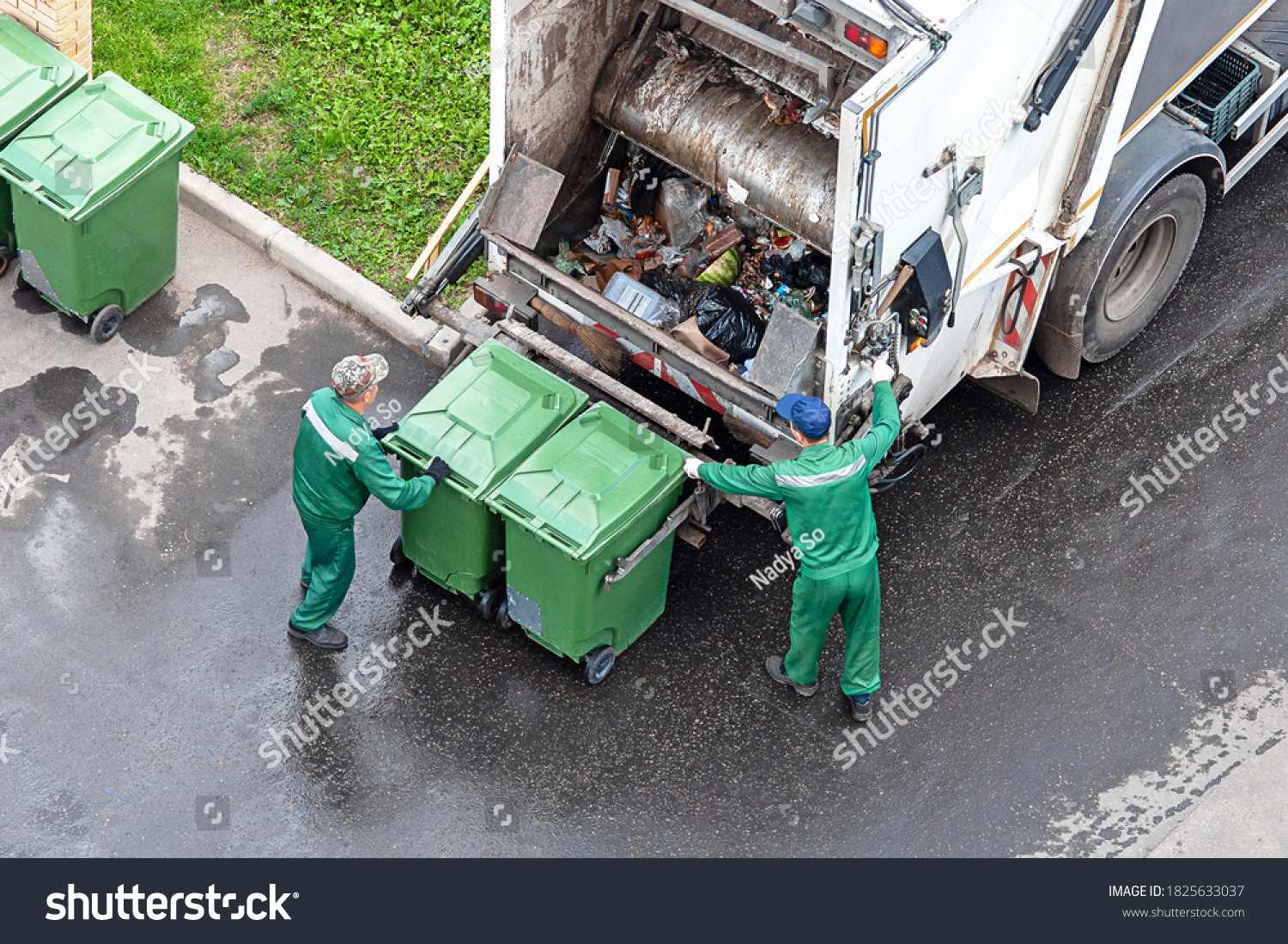 two workers loading mixed domestic waste in waste collection truck #1825633037