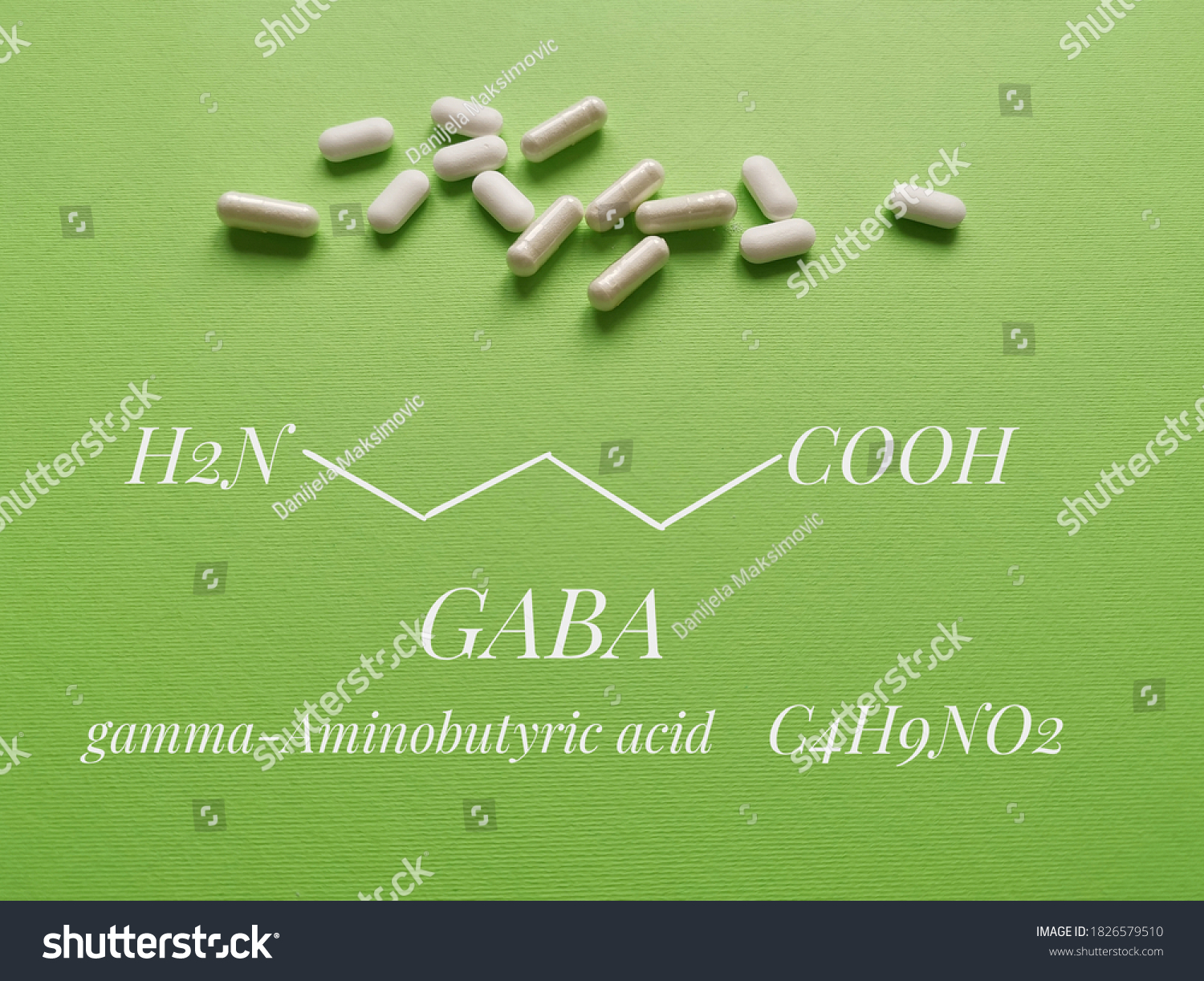 Structural chemical formula of gamma-aminobutyric acid (or GABA) molecule with white pills. GABA is a naturally occurring amino acid that works as a neurotransmitter; used as a dietary supplement. #1826579510