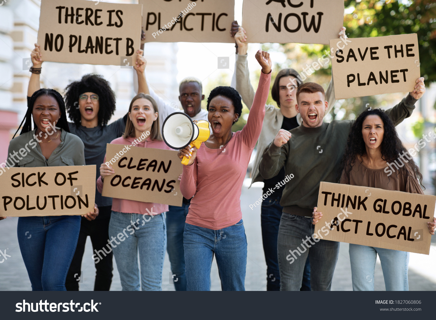 Motivated group of demonstrators striking on the street, fighting for environmental protection. Multiracial group of young people with placards protesting for healthy environment, green planet #1827060806