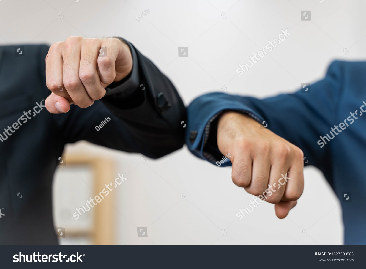 Coronavirus. Business workers elbow greeting in a white background. Elbow greeting because coronavirus. Business workers back to work in office after lockdown. #1827300563