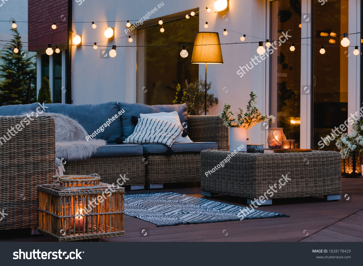 Summer evening on the patio of beautiful suburban house with lights in the garden garden #1828178429