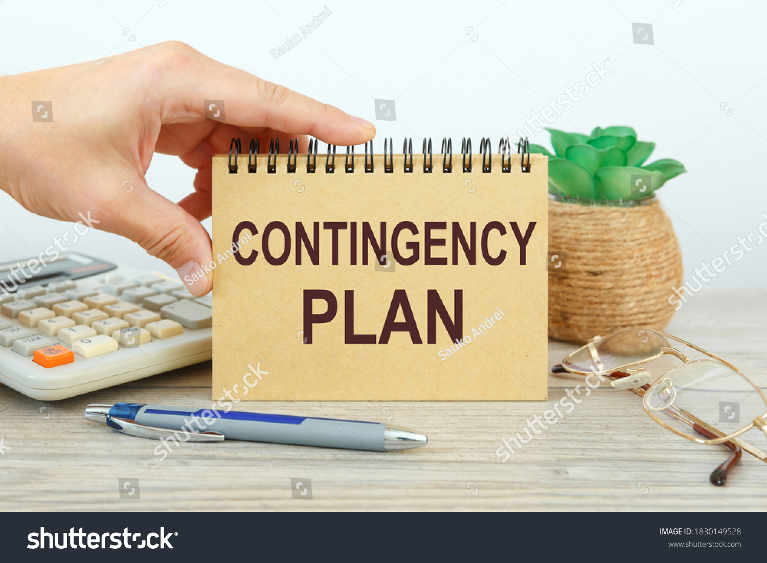 Notepad with text Contingency Plan on a white background, near calculator and office supplies. Business concept. #1830149528