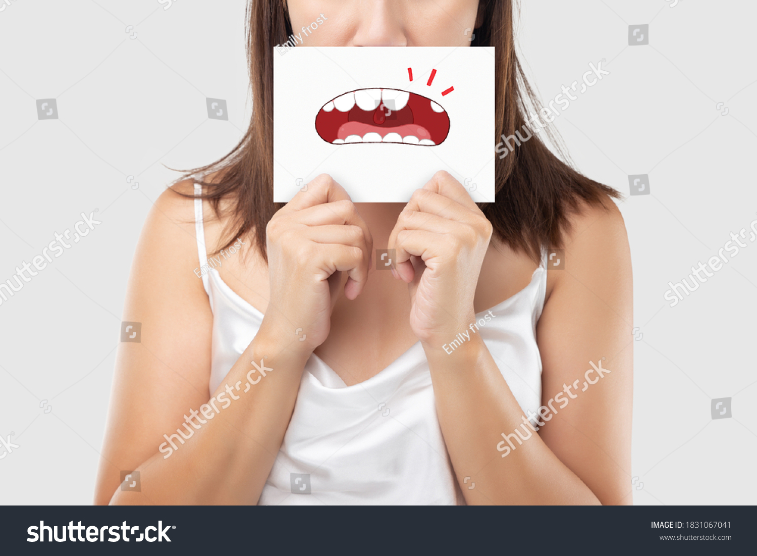 Asian woman in the white wear holding a white paper with the broken tooth cartoon picture of his mouth against the gray background, Decayed tooth, The concept with healthcare gums and teeth #1831067041