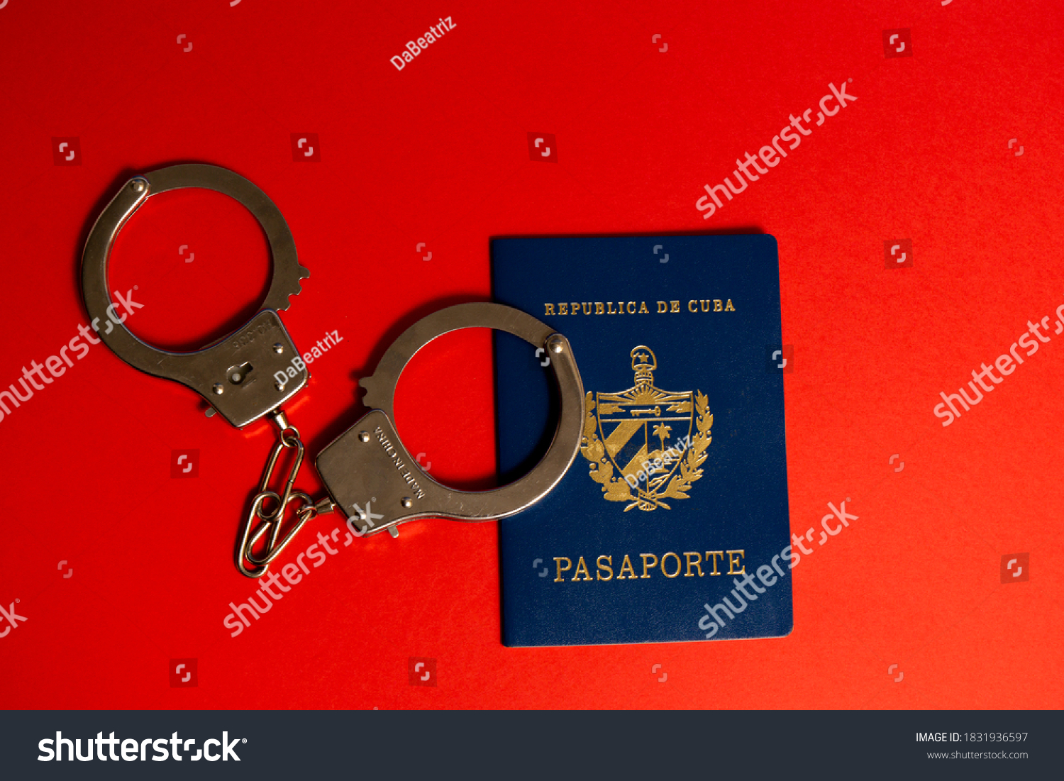 Cuban passport with handcuffs on red background #1831936597