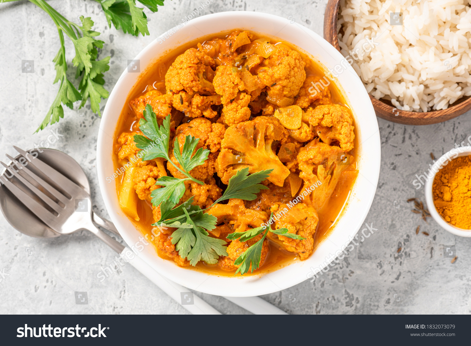 Cauliflower stew with curry, cumin, turmeric and other spices in a white bowl on a grey concrete background top view. Curry roasted cauliflower. #1832073079