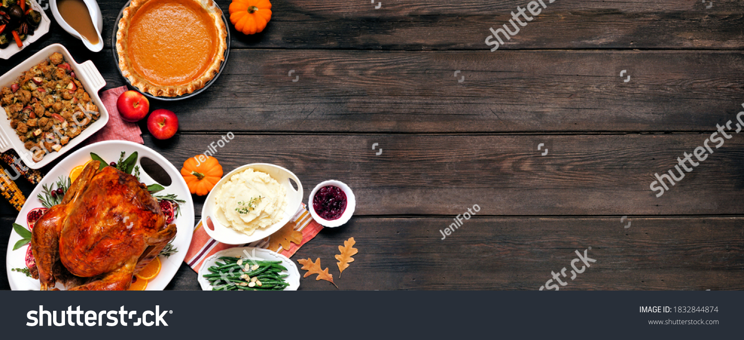 Traditional Thanksgiving turkey dinner. Top down view corner border on a dark wood banner background with copy space. Turkey, mashed potatoes, dressing, pumpkin pie and sides. #1832844874