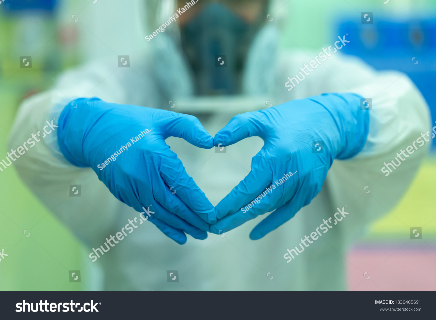 The doctor is encouraging patients and relatives infected with COVID after the treatment of patients. Doctor with a medical mask and hands in latex glove shows the symbol of the heart.  #1836465691