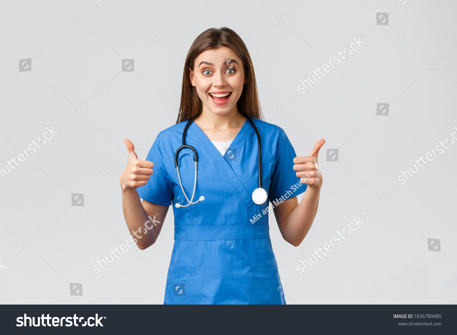 Medical workers, healthcare, covid-19 and vaccination concept. Enthusiastic and upbeat female nurse, doctor in blue scrubs, think wonderful idea, show thumbs-up in approval #1836789985