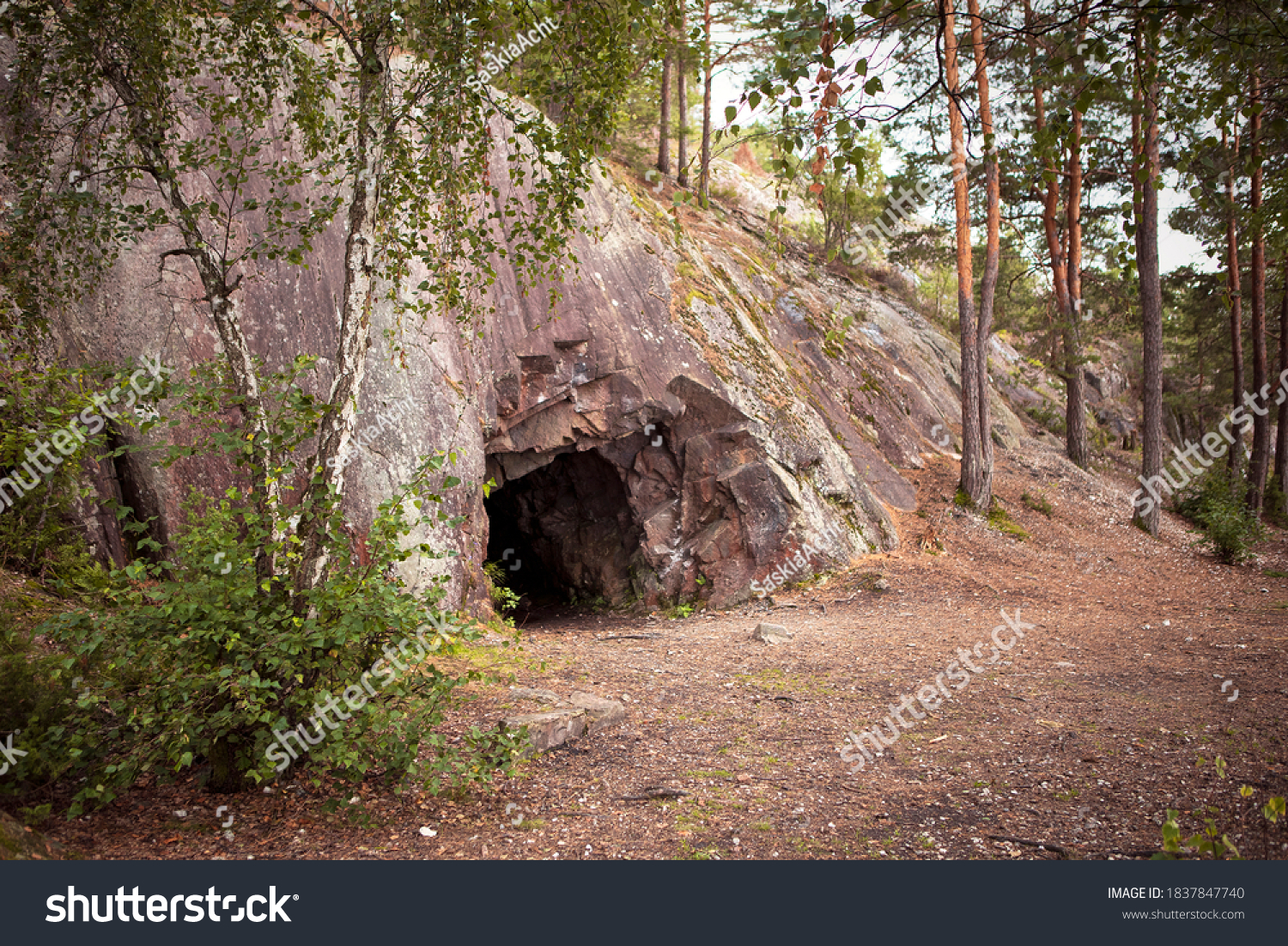 Landscape with cave and forest. Scenic entrance to cave. Rock wall with a dark hole. Spro, Mineral historic mine. Nesodden Norway. Nesoddtangen peninsula. #1837847740