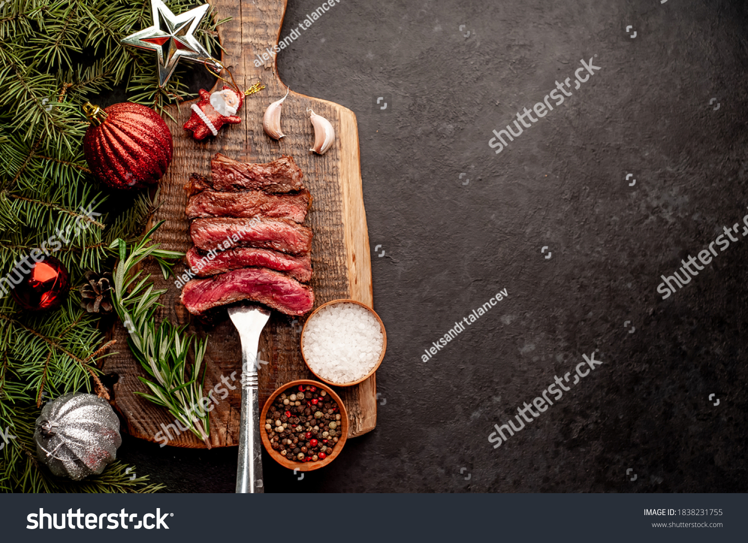 
Different degrees of roasting of steak on a meat fork for Christmas on a background of a stone with a spruce and Christmas toys with copy space for your text #1838231755