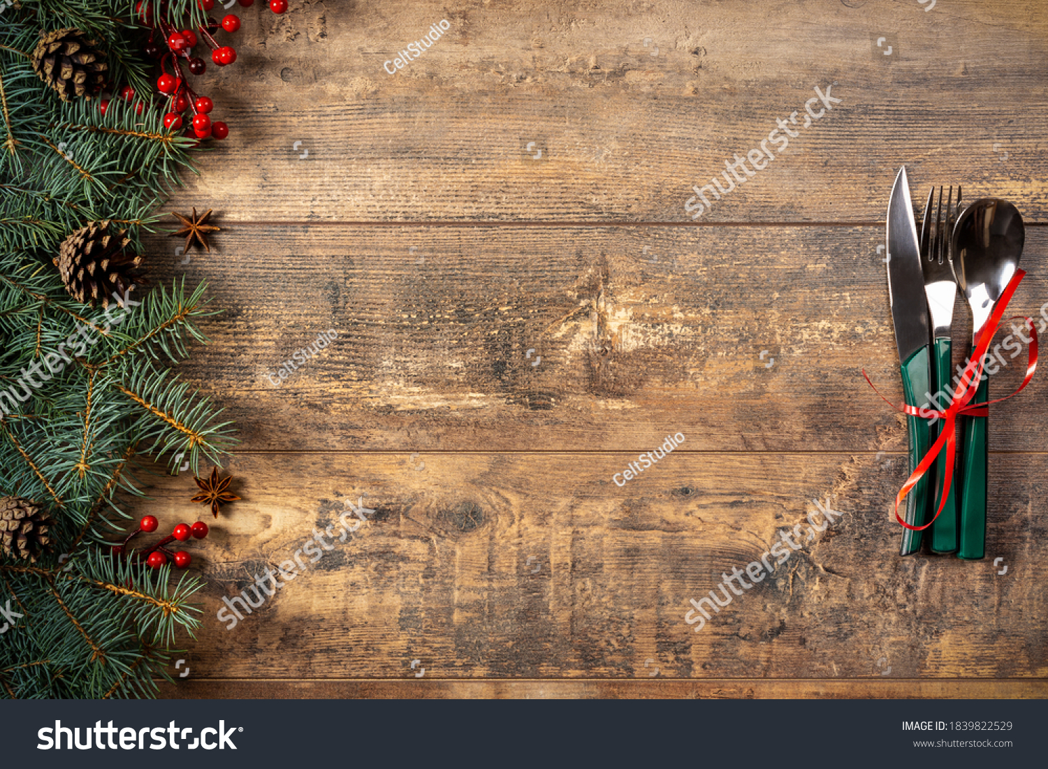 festive New Year Christmas dinner concept. Christmas decorations and Cutlery on a dark rustic table. Christmas table place setting. Winter holidays background. Top view, flat lay, copy space #1839822529