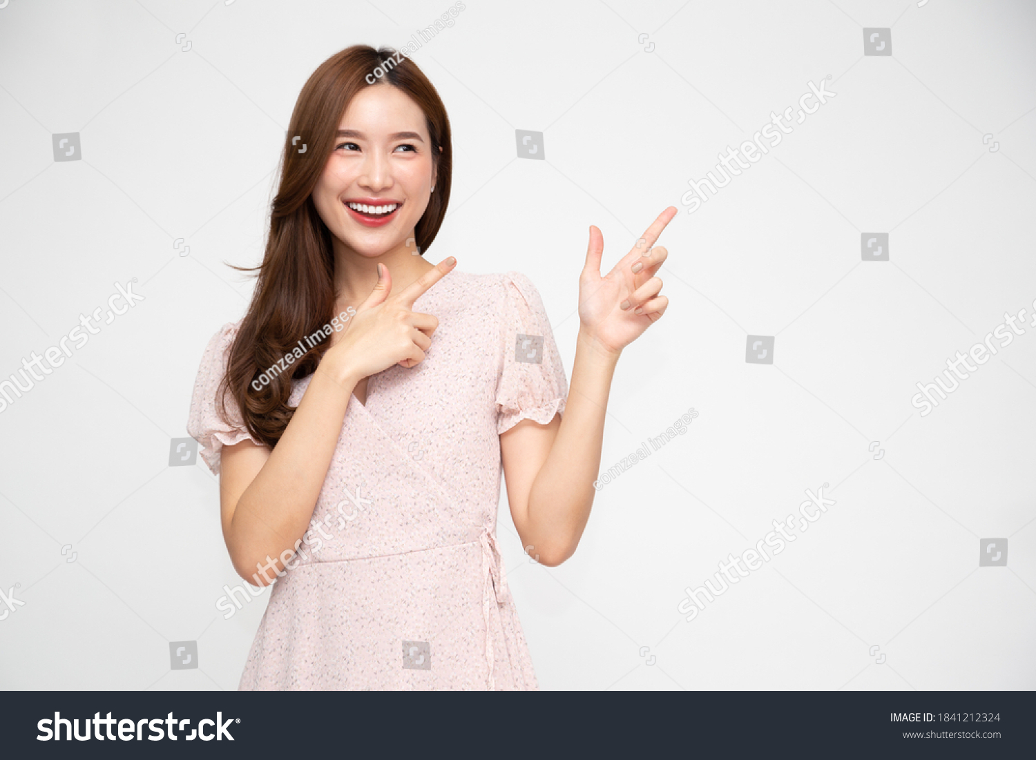 Young elegant beautiful Asian woman smiling and pointing to empty copy space isolated on white background #1841212324