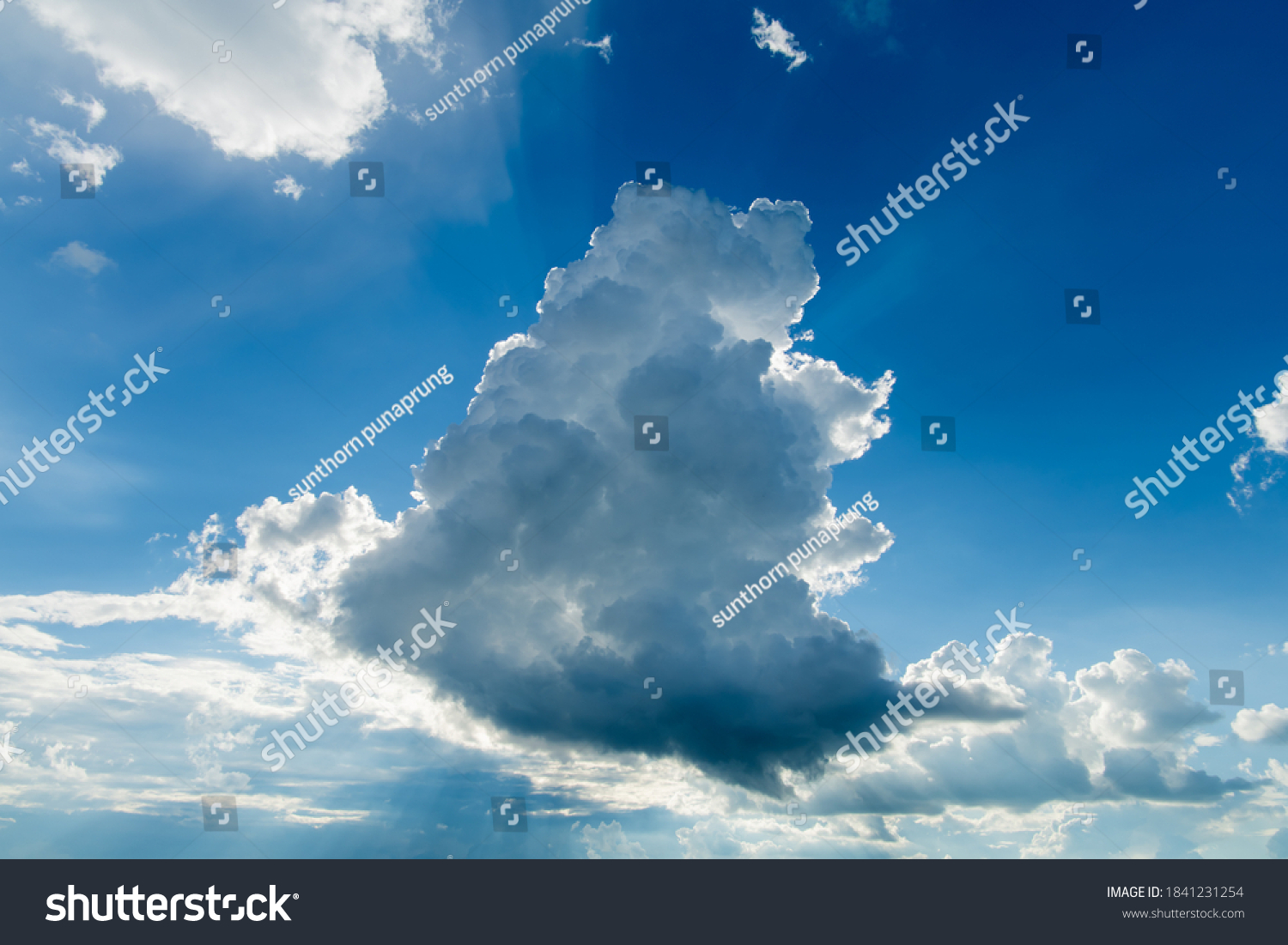 A big and fluffy cumulonimbus cloud in the blue sky. #1841231254