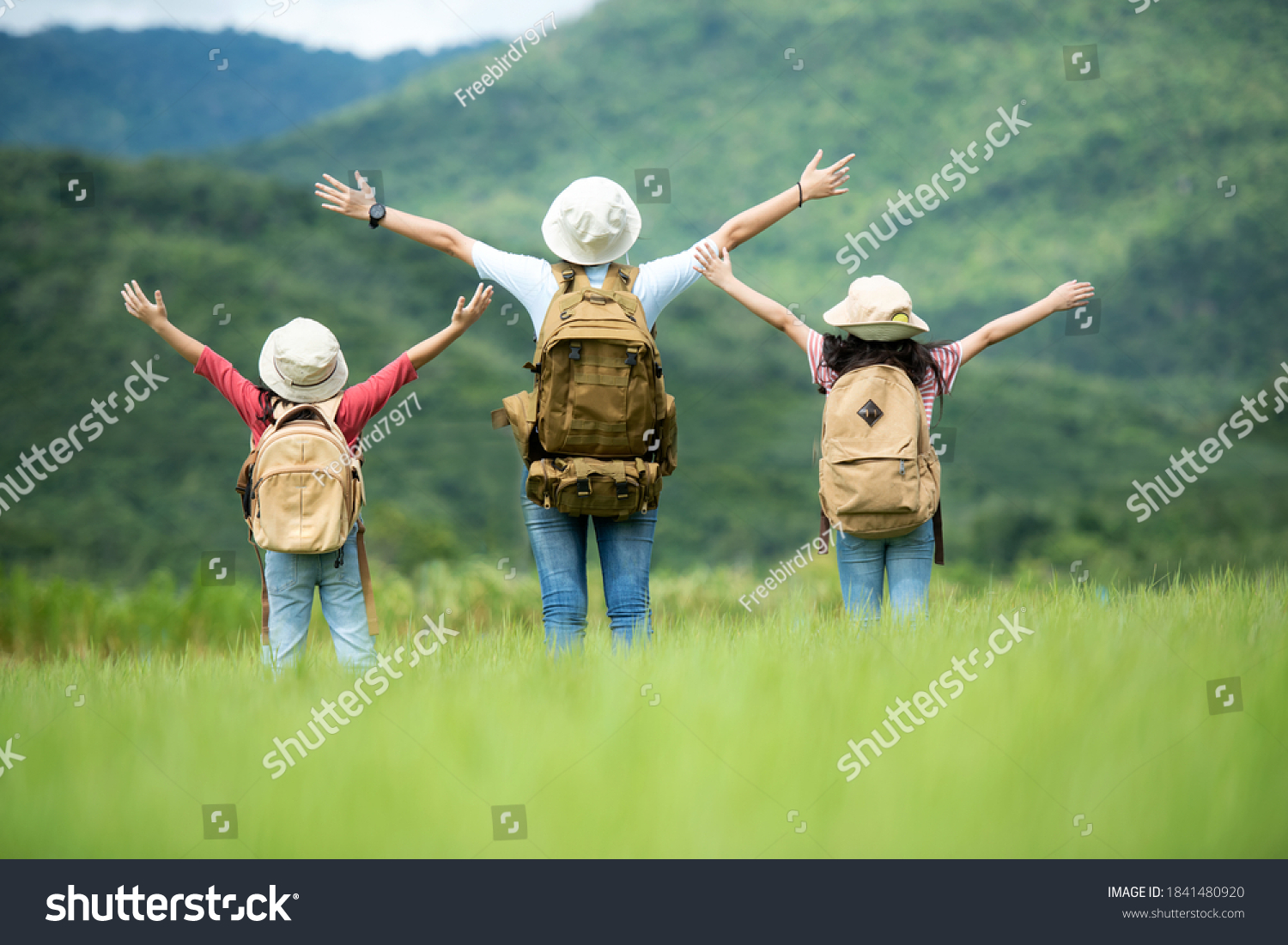 Group family children travel nature trips raise arms and standing see mountain outdoors, adventure and tourism for destination leisure trips for education and relax in nature park. Travel vacations  #1841480920