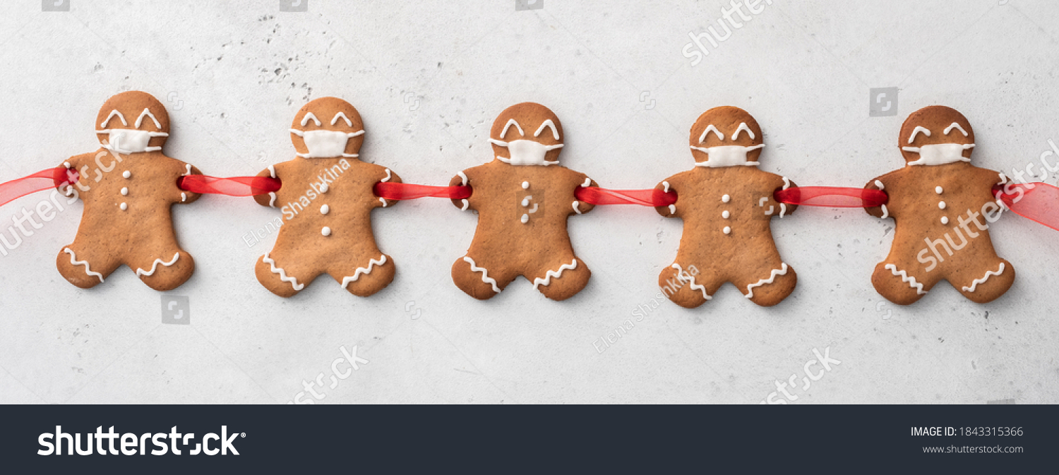 Stay home quarantine from Covid-19. Christmas gingerbread men with a masks #1843315366