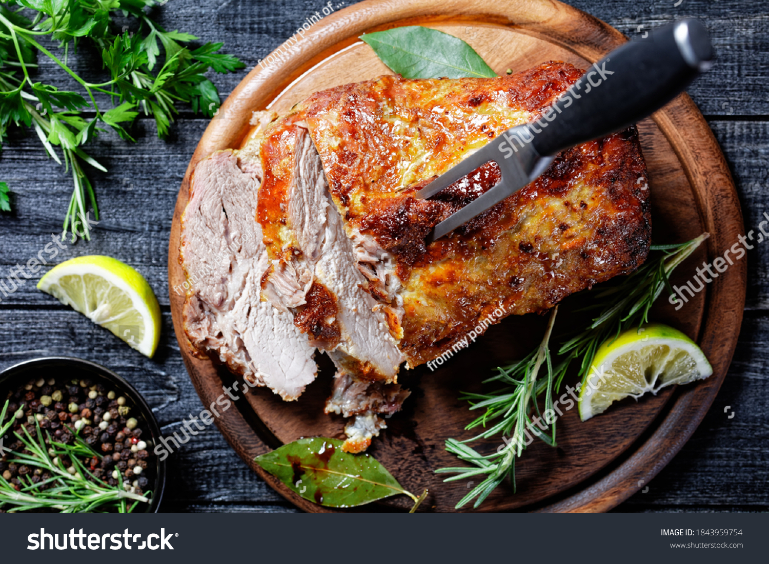 Sunday roasted pork tenderloin, juicy and succulent oven-baked piece of meat rubbed with mustard and spices: rosemary, bay leaf, lime juice, and pepper on a wooden background, close-up, top view #1843959754