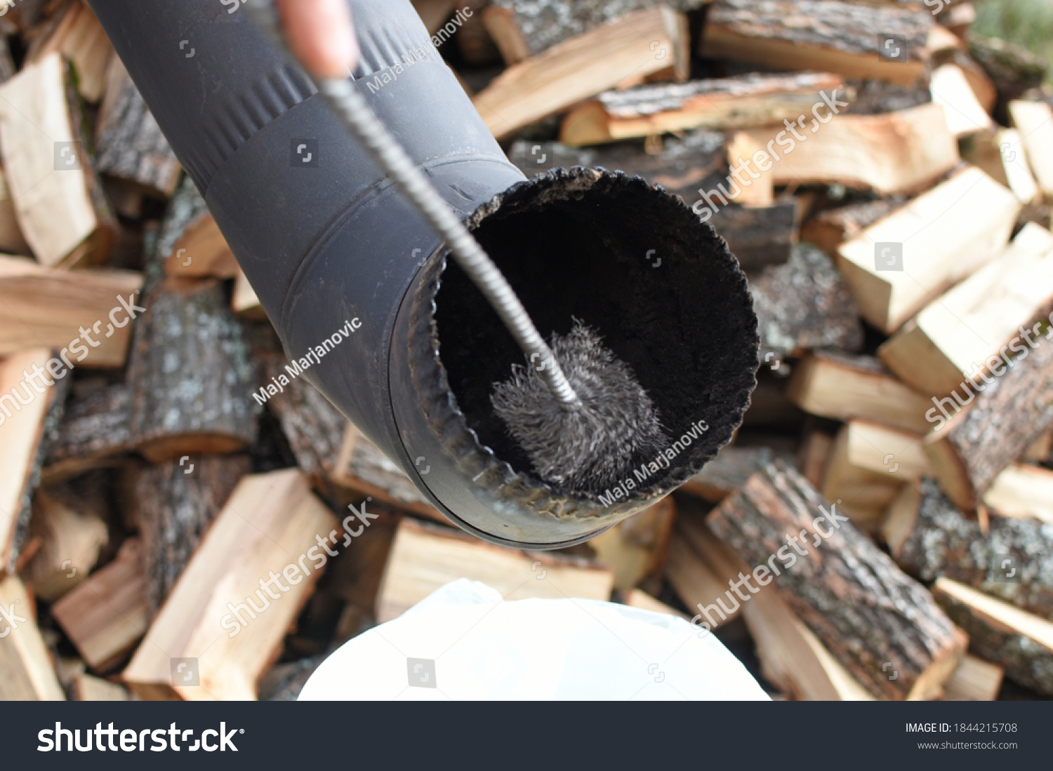 Man cleaning chimney pipe outside. Cleaning a wood burning stove. Chimney sweep cleaning #1844215708