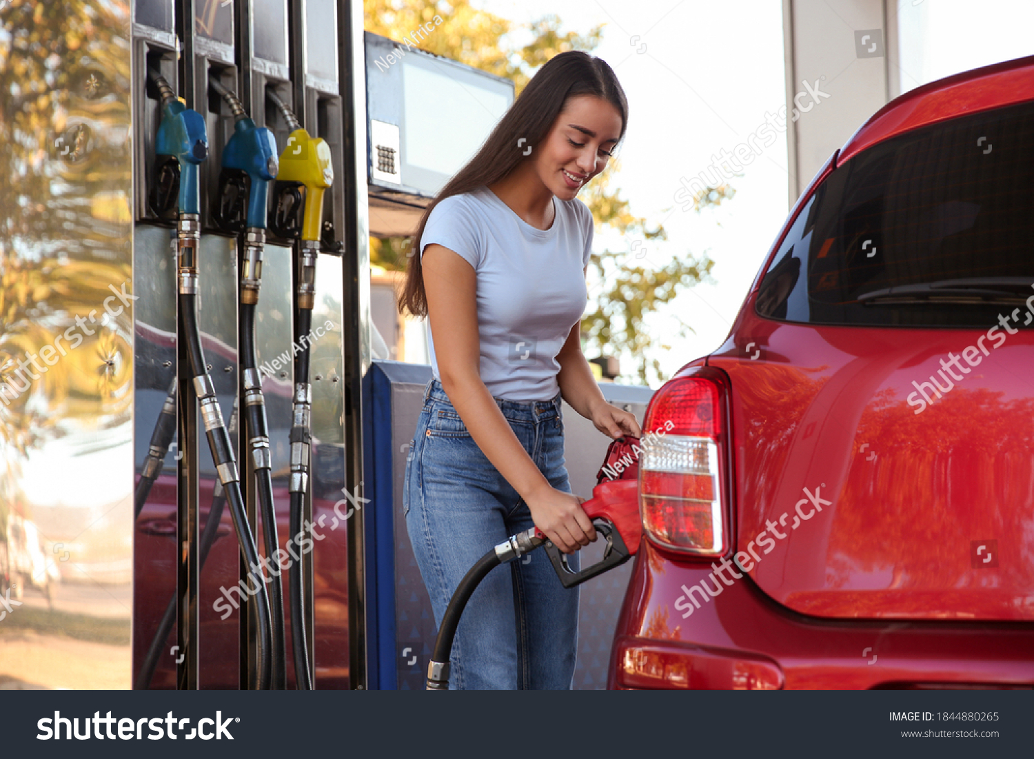Young woman refueling car at self service gas station #1844880265