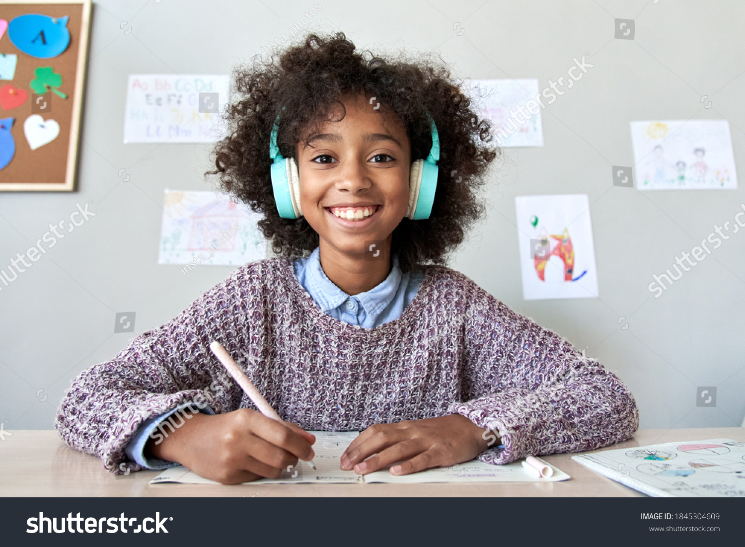 Happy african american kid child girl wearing headphones looking at web cam talking with remote teacher on distance learning video conference call chat class, headshot zoom portrait, webcam view. #1845304609