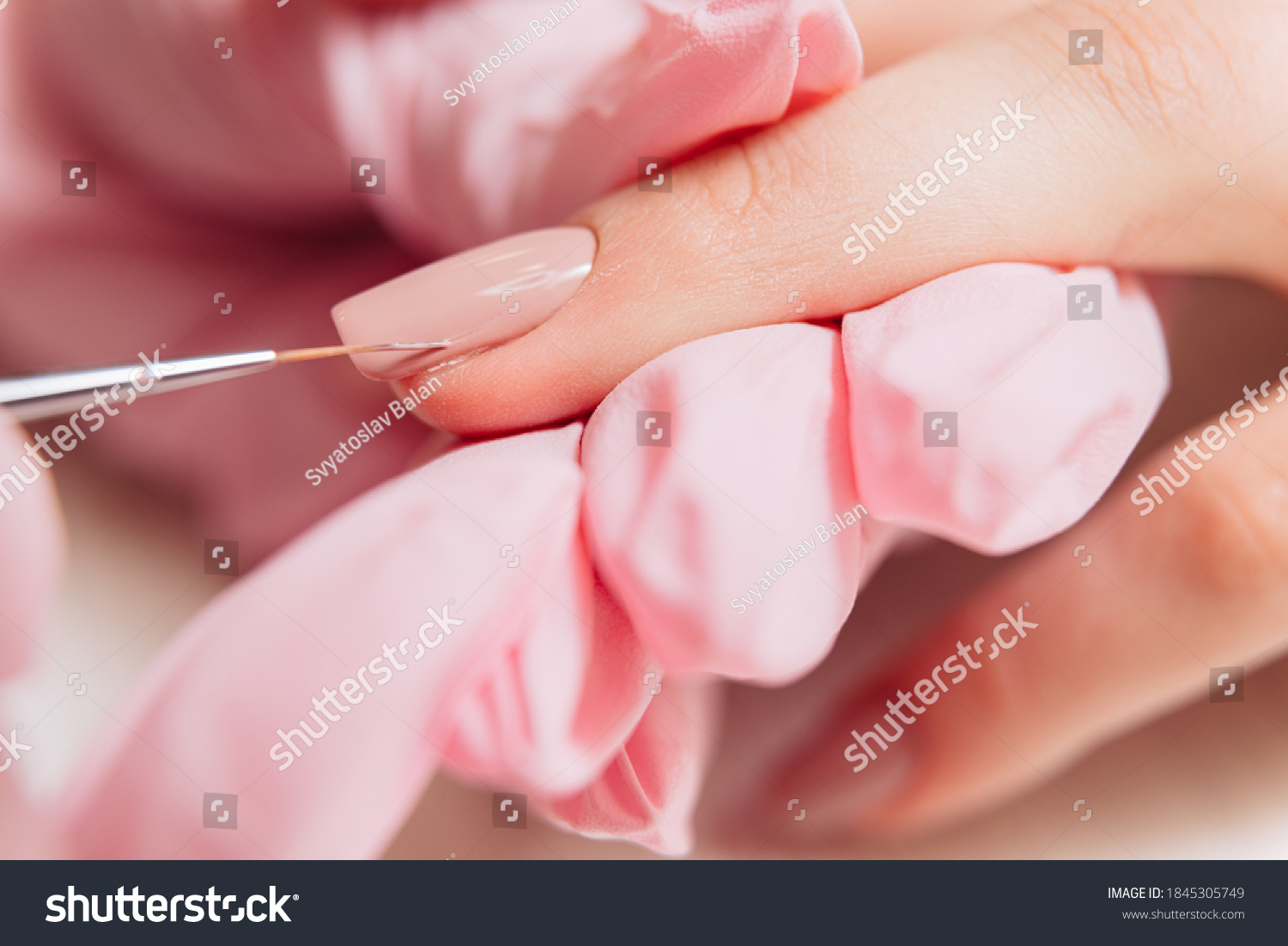 Manicure process. Manicurist paints fingernails. Nail polish. #1845305749