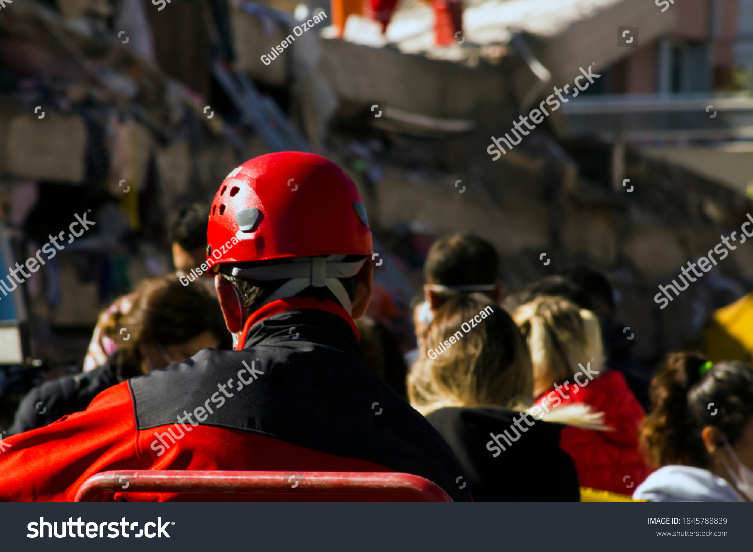 The Back of the search and rescue worker in front of blurred building destroyed in the earthquake,watching and resting #1845788839