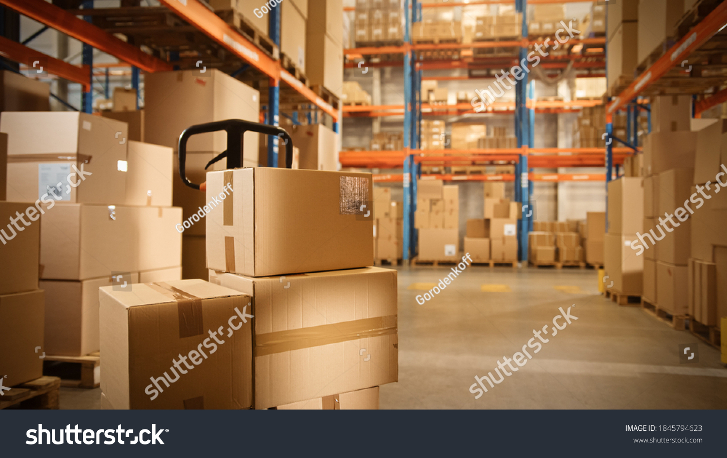 Big Retail Warehouse full of Shelves with Goods Stored on Manual Pallet Truck in Cardboard Boxes and Packages. Forklift Driving in Background. Logistics and Distribution Facility for Product Delivery #1845794623