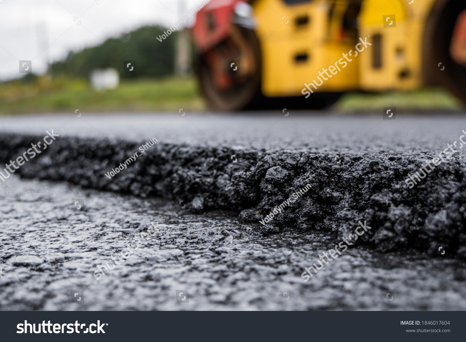 Asphalt road roller with heavy vibration roller compactor press new hot asphalt on the roadway on a road construction site. Heavy Vibration roller at asphalt pavement working. Repairing. #1846017604