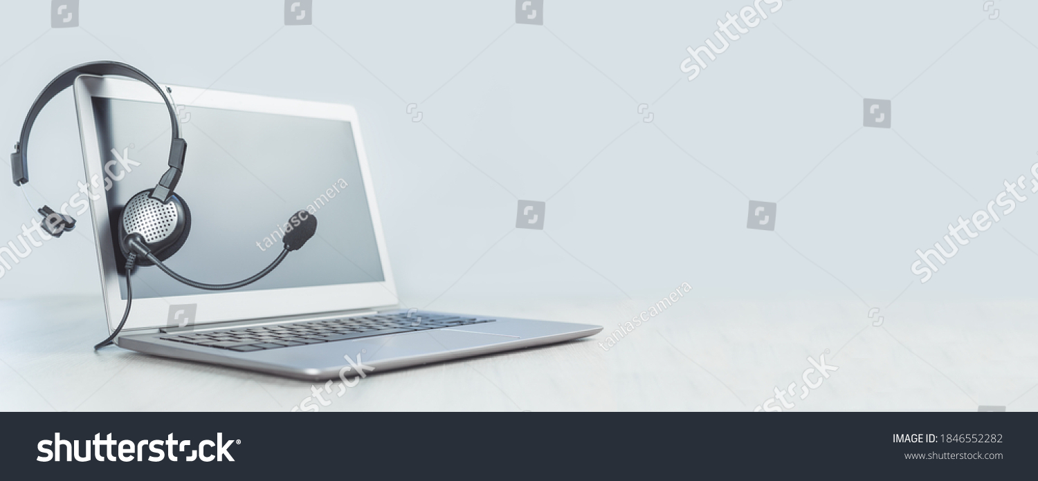 Laptop. Mockup screen and headphones on grey desk and plain background banner. Helpdesk or call center headset. Distant learning or working from home, online courses or support center concept. #1846552282