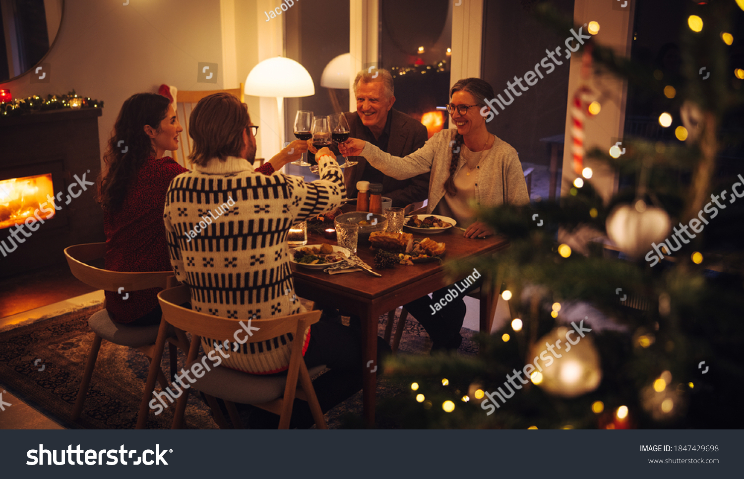 Family having a Christmas eve dinner together. European family toasting wine and enjoying dinner on Christmas eve. #1847429698
