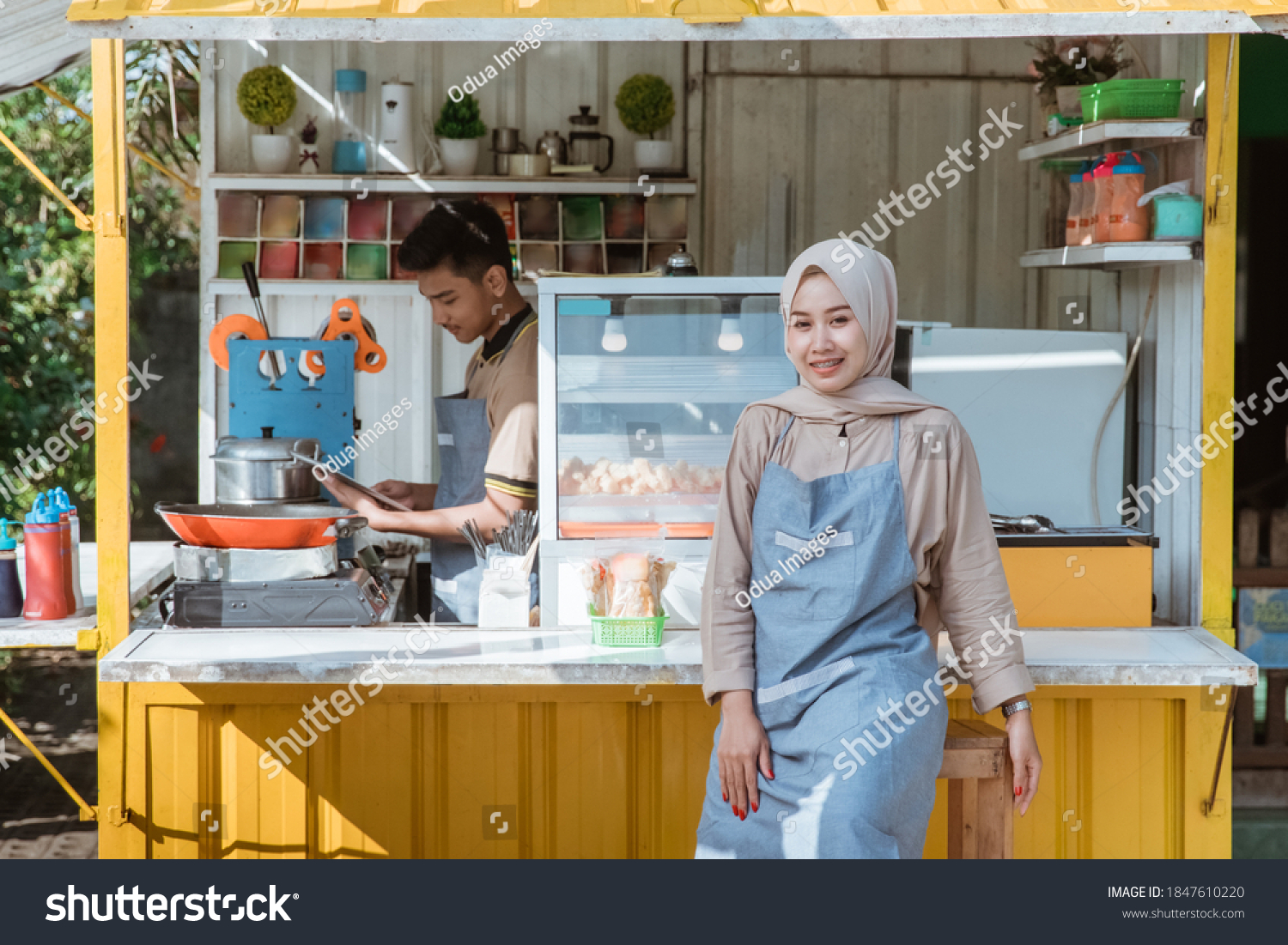 beautiful muslim woman entrepreneur at her small food stall smiling to camera #1847610220
