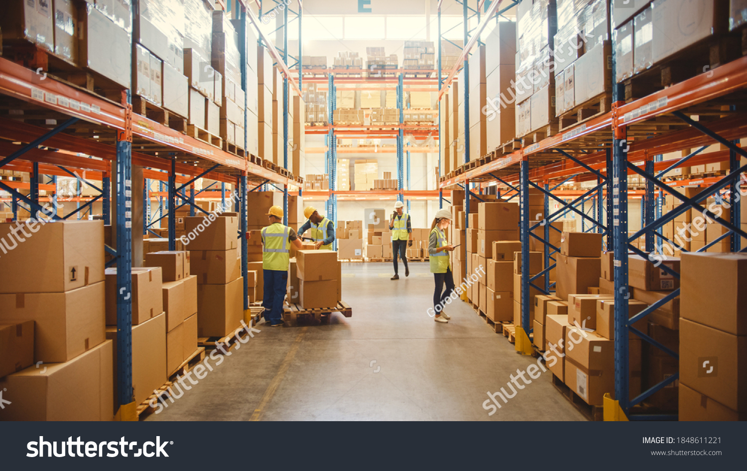 Retail Warehouse full of Shelves with Goods in Cardboard Boxes, Workers Scan and Sort Packages, Move Inventory with Pallet Trucks and Forklifts. Product Distribution Delivery Center. #1848611221
