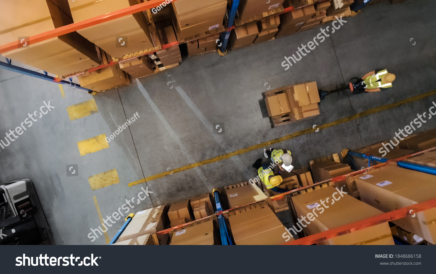 Top-Down View: Worker Moves Cardboard Boxes using Hand Pallet Truck, Walking between Rows of Shelves with Goods in Retail Warehouse. People Work in Product Distribution Logistics Center #1848686158