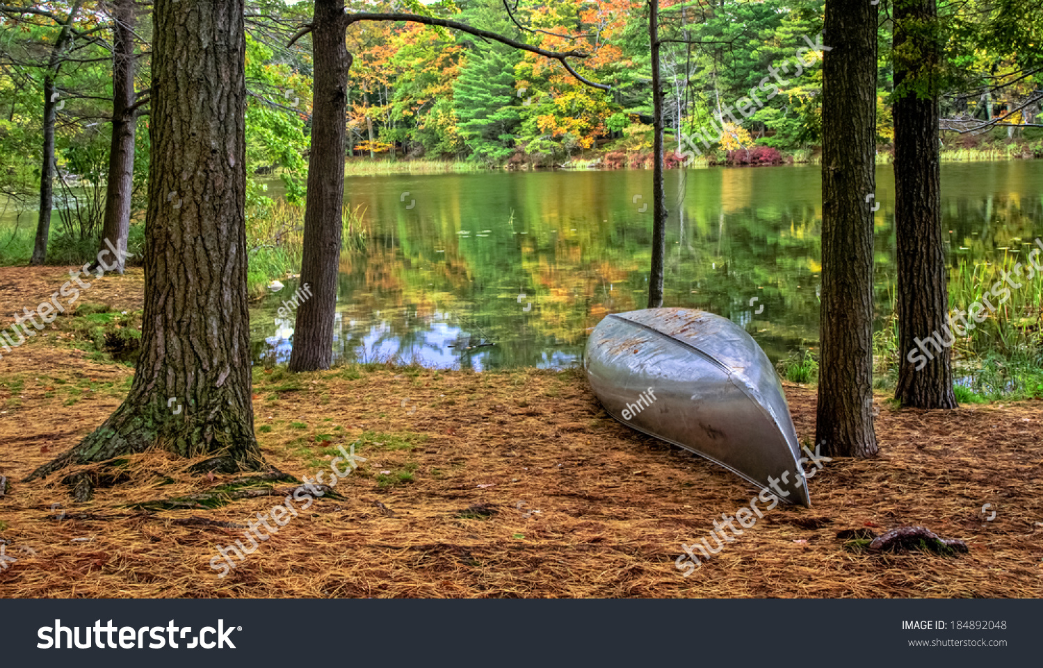 Autumn Lakeshore. Aluminum canoe along the forested lakeshore. Ludington State Park. Ludington, Michigan. #184892048