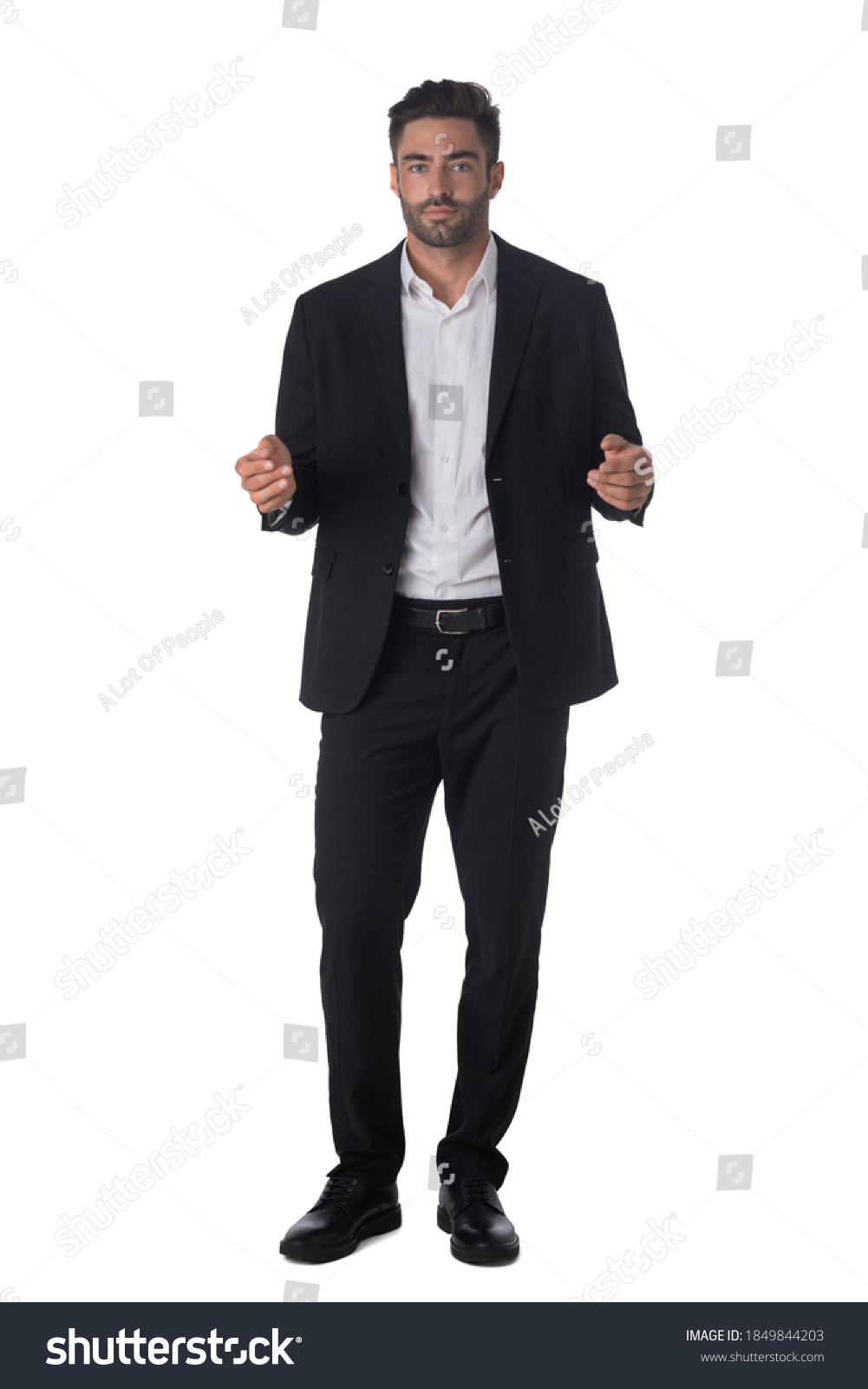 Full length portrait of young handsome business man in black suit holding something in hands studio isolated on white background #1849844203