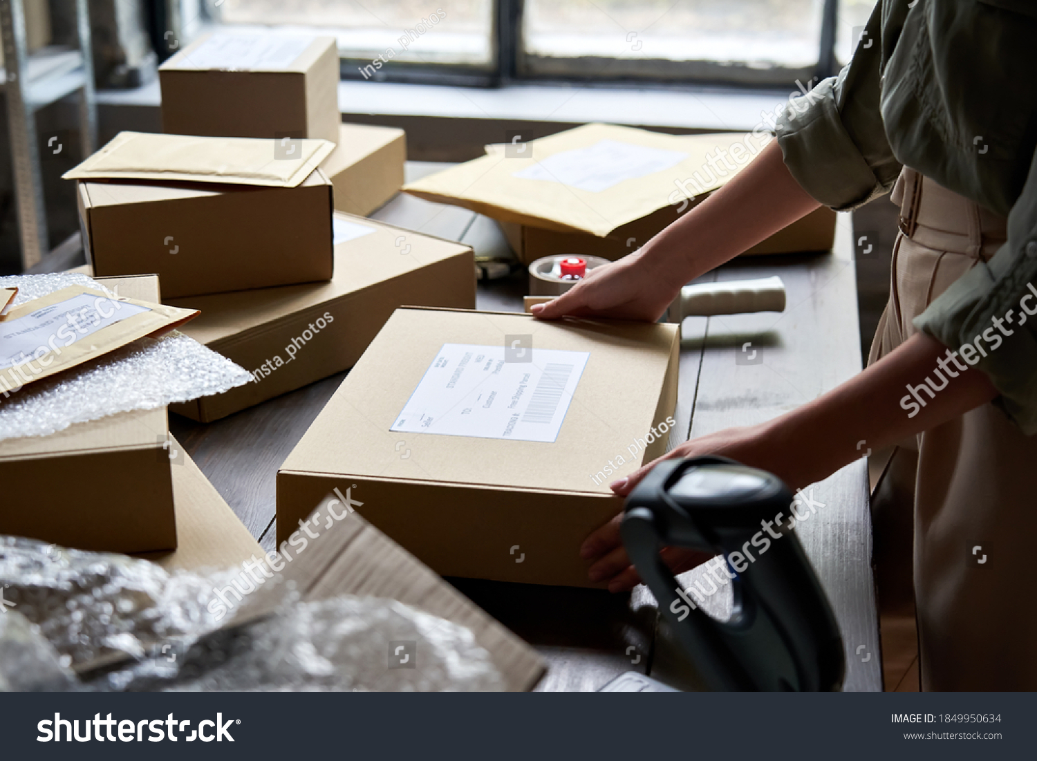 Female distribution warehouse worker or seller packing ecommerce shipping order box for dispatching, preparing post courier delivery package, dropshipping commerce retail shipment service concept. #1849950634