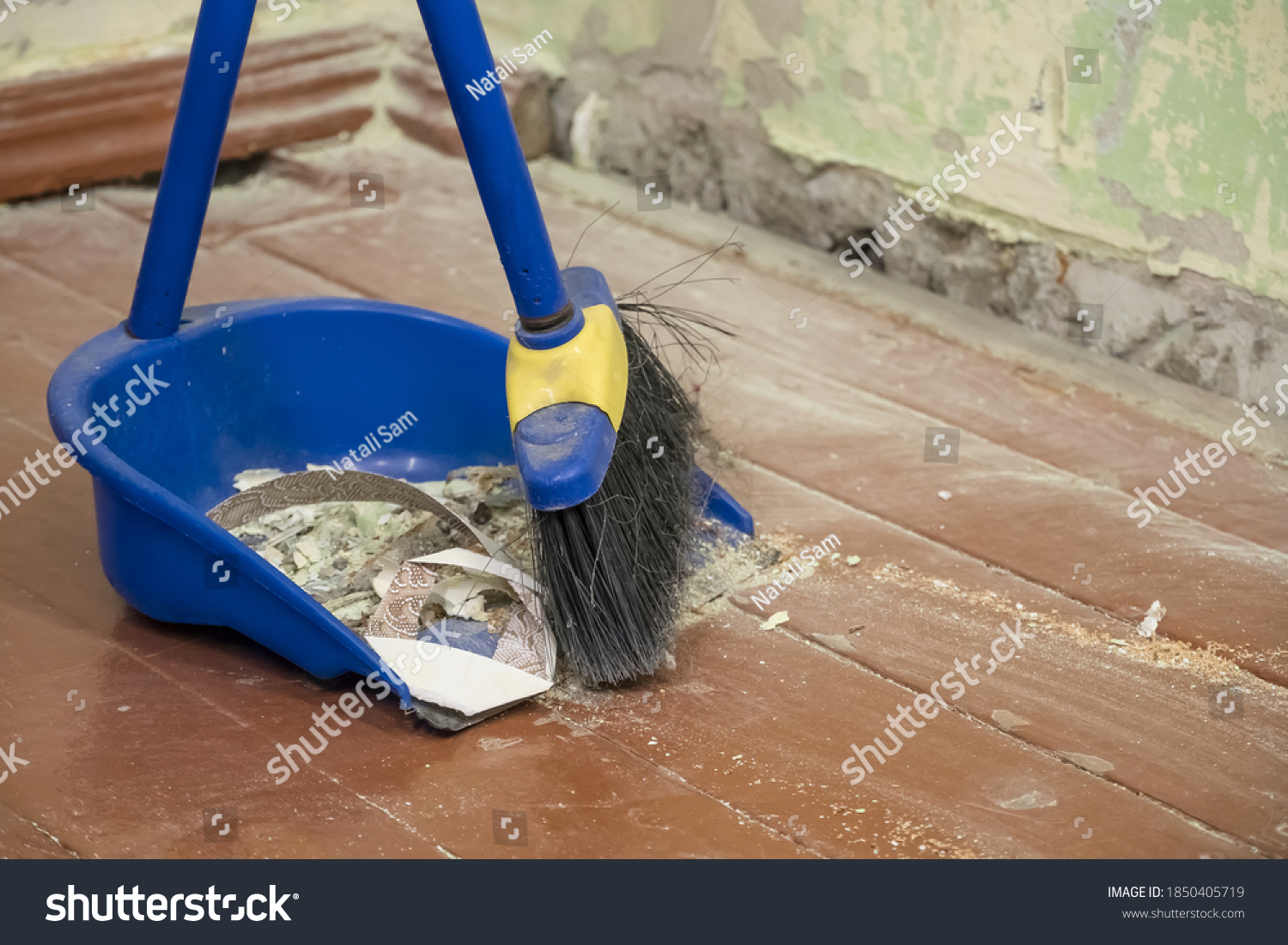 Clean up after repairs. Sweep up construction debris with a brush in a dustpan. Sweeping at home. Tools for cleaning the house. Make home repairs. The dust and debris after the renovation. #1850405719