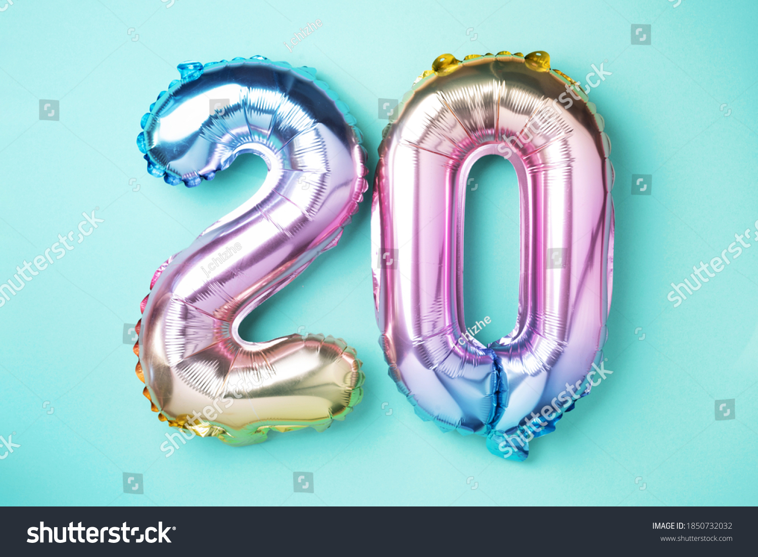 Rainbow foil balloon number, digit twenty. Birthday greeting card with inscription 20. Anniversary concept. Top view. Colored numeral on blue background. Numerical digit, Celebration event, template. #1850732032