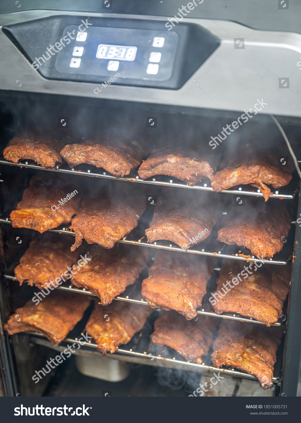 smoke rising around a slow cooked beef brisket on a smoker barbecue grilling concept #1851005731