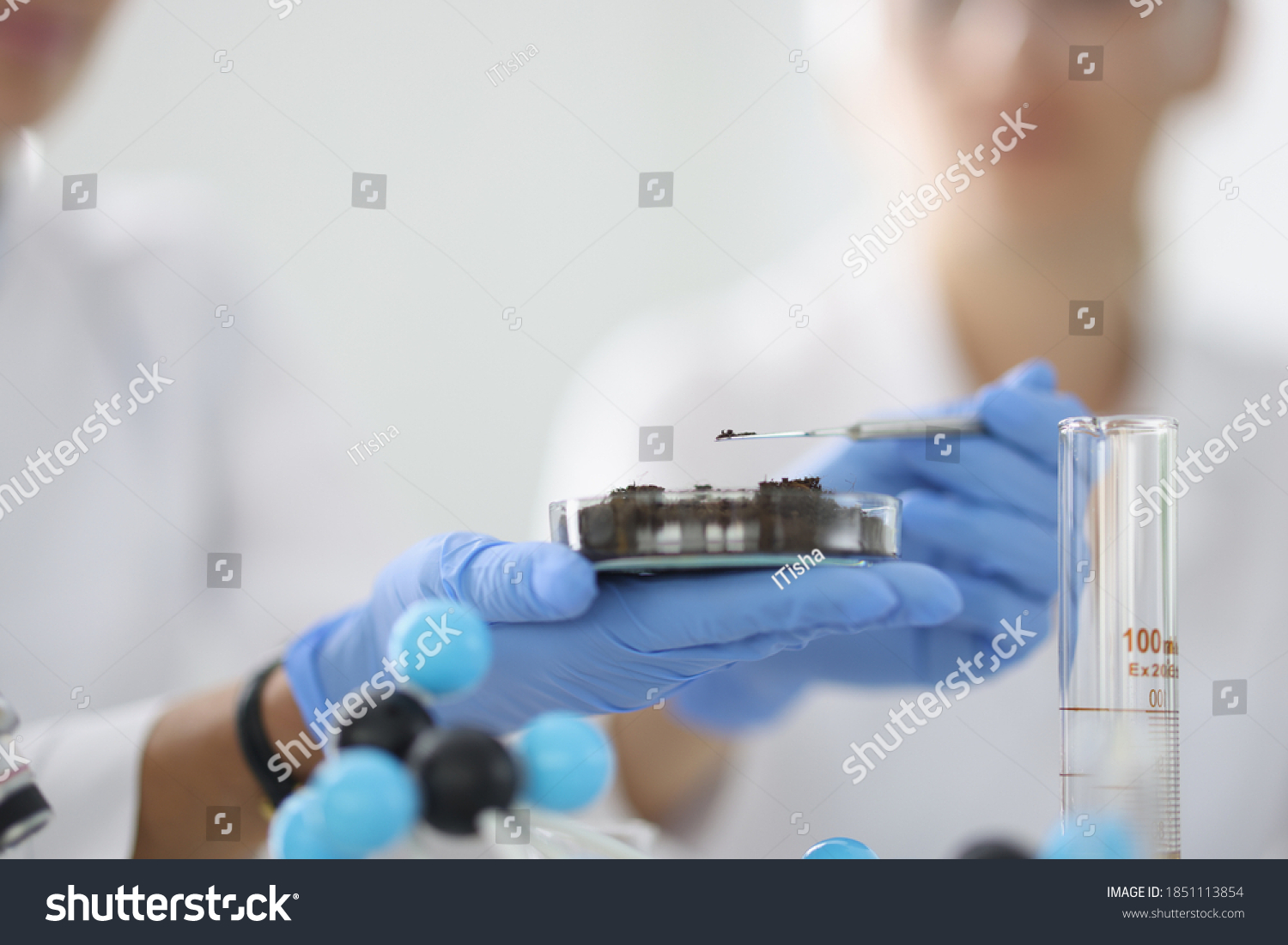 Researcher holds glass flask with earth in his hand. Basic soil research methods concept #1851113854