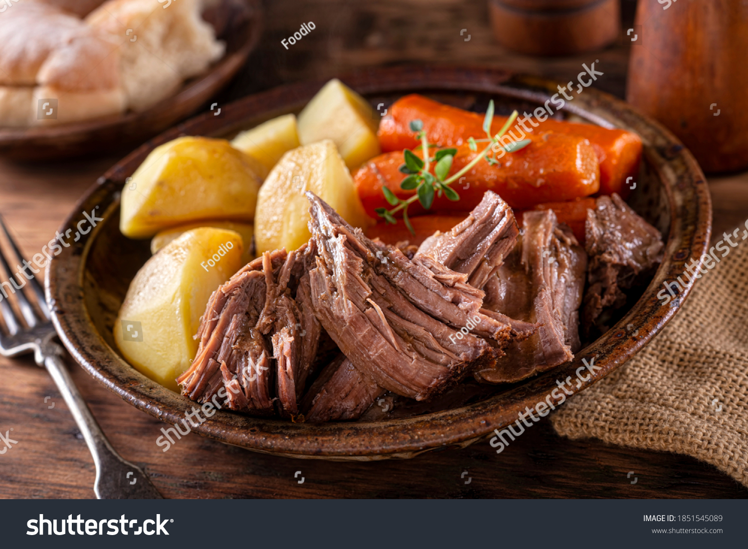 A plate of delicious beef pot roast with potatoes and carrots with thyme garnish. #1851545089