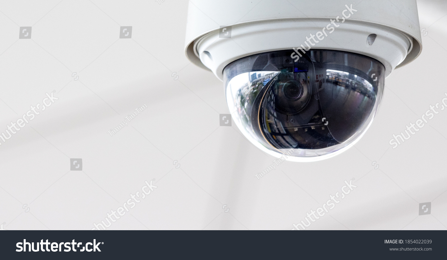 Closeup of white dome type cctv digital security camera installed on ceiling for observation. #1854022039