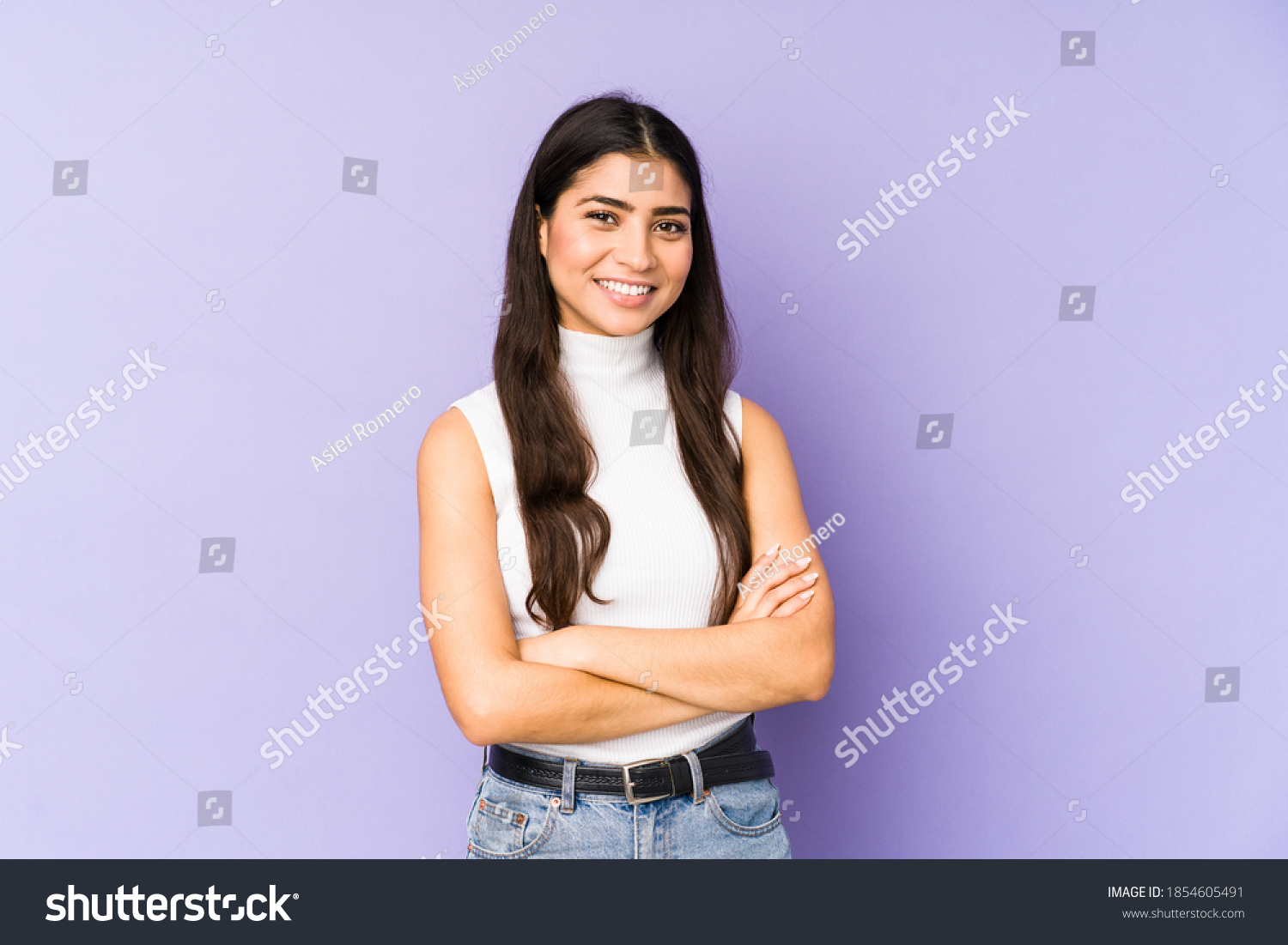 Young indian woman isolated on purple background who feels confident, crossing arms with determination. #1854605491