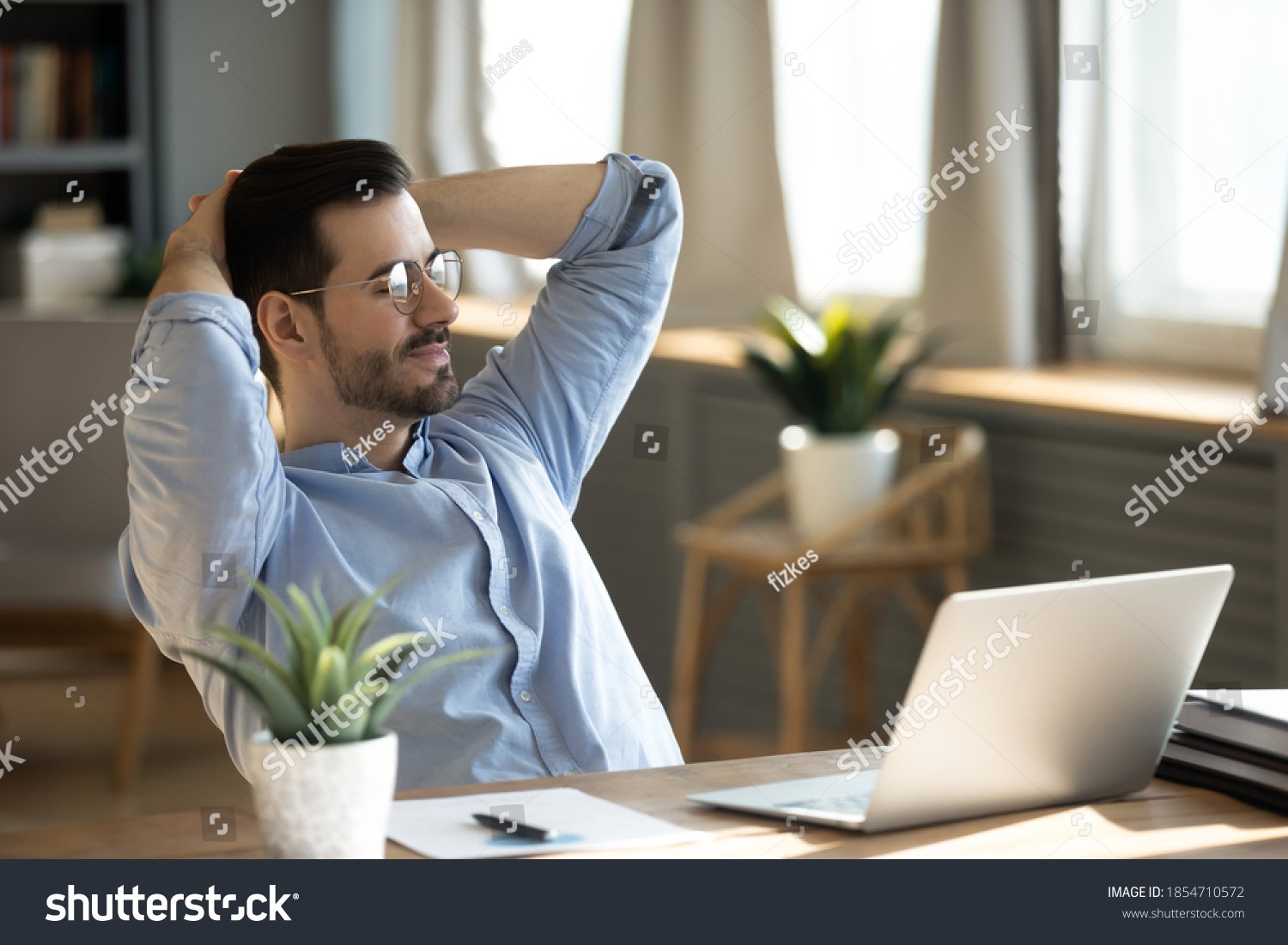 Handsome young businessman resting at workplace lean on comfort chair closed eyes enjoy fresh conditioned air. Satisfied employee finish work feels serene relaxing in modern office, no stress concept #1854710572