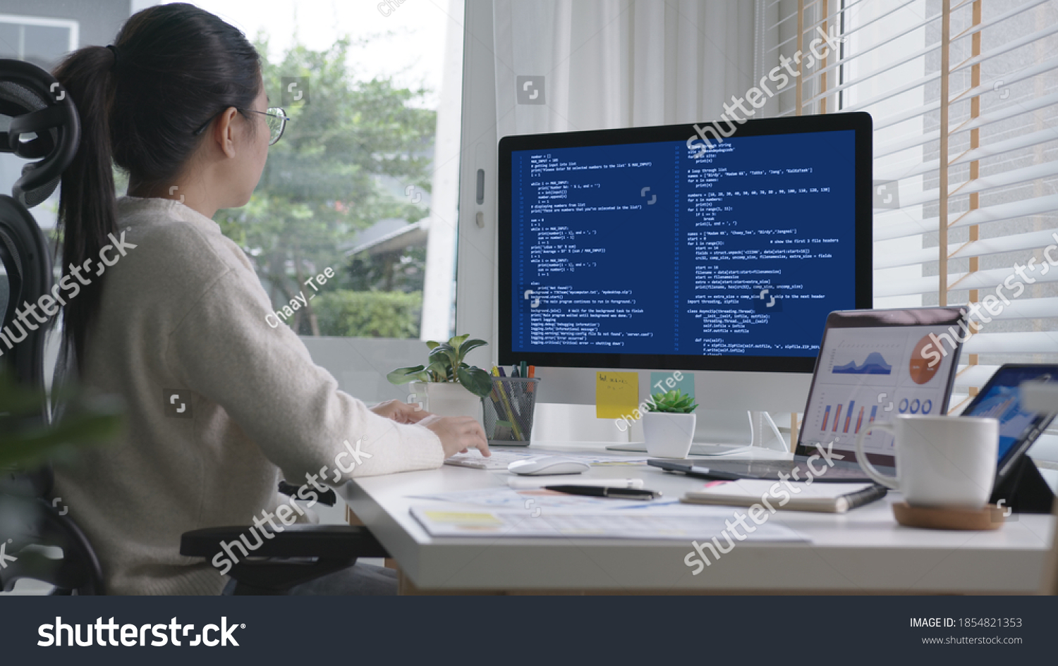 Back rear view of young asian woman, freelance data scientist work remotely at home coding programing on Big data mining, AI data engineering, IT Technician Works on Artificial Intelligence Project. #1854821353