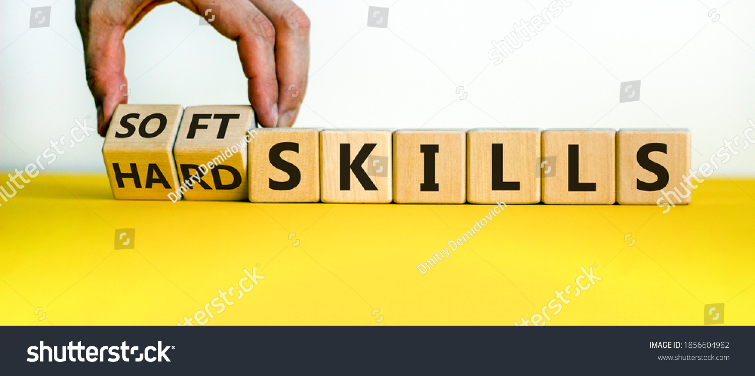 Hard skills versus soft skills. Hand flips cubes and changes the expression 'hard skills' to 'soft skills' or vice versa. Beautiful yellow table, white background. Business concept. Copy space. #1856604982