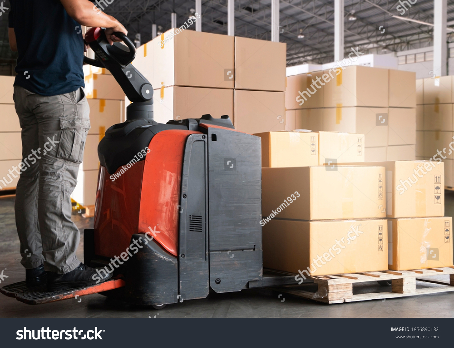 Warehouse worker working with electric forklift pallet jack unloading cardboard boxes on pallet at the warehouse.Cargo shipment boxes, Packaging, Warehousing storage. #1856890132
