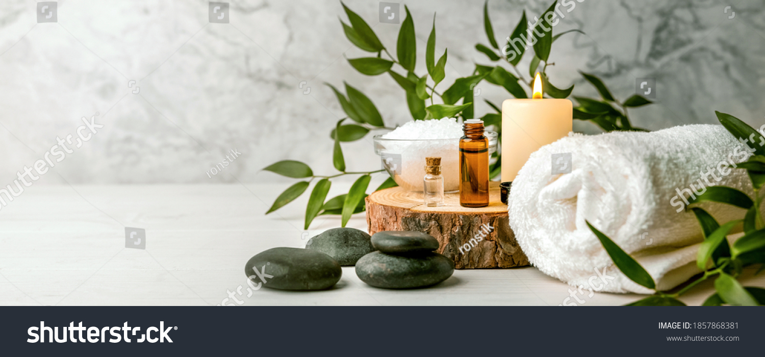 beauty treatment items for spa procedures on white wooden table. massage stones, essential oils and sea salt. copy space #1857868381